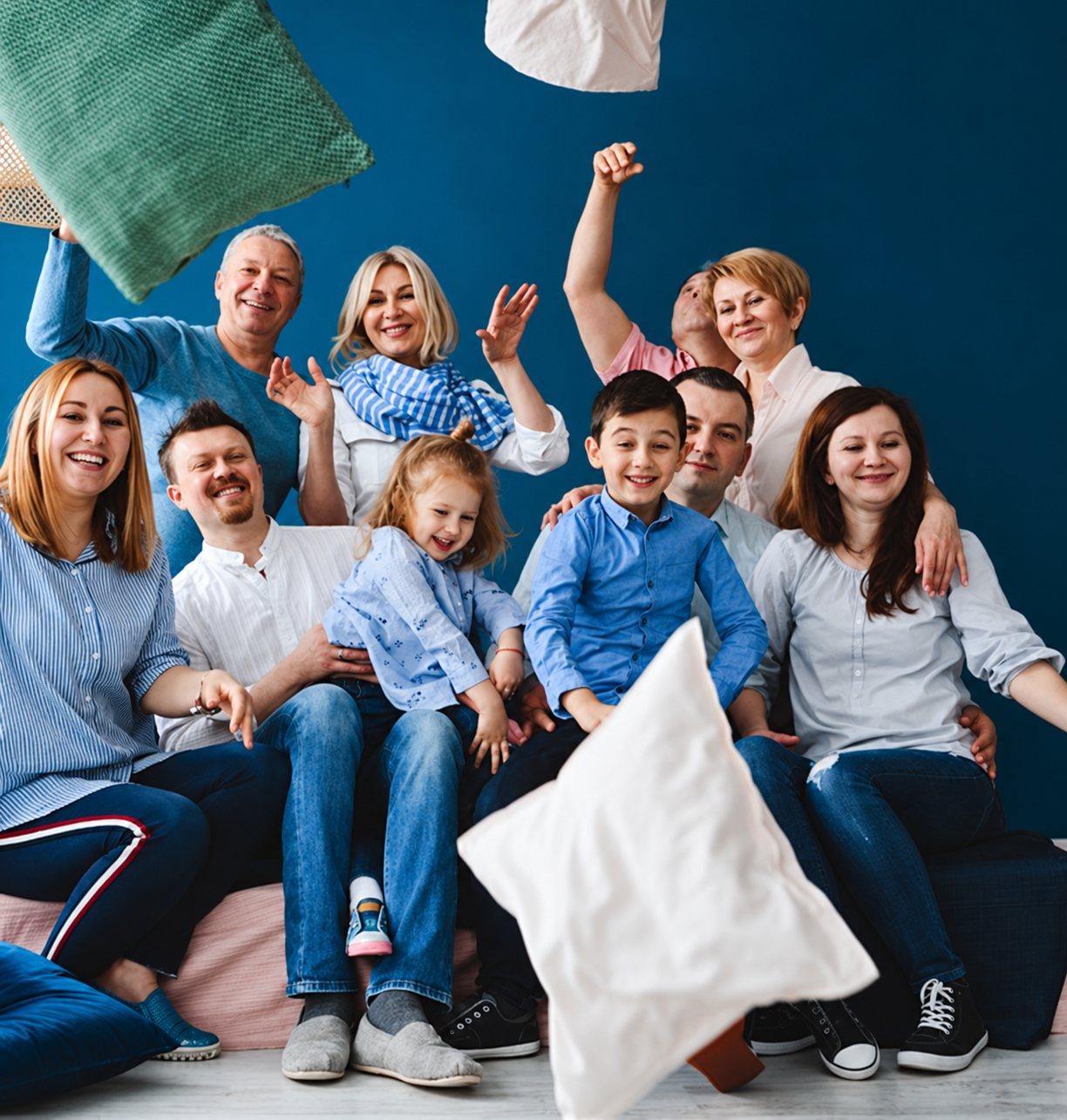 Famille de plusieurs générations riant pendant une bataille d’oreillers.